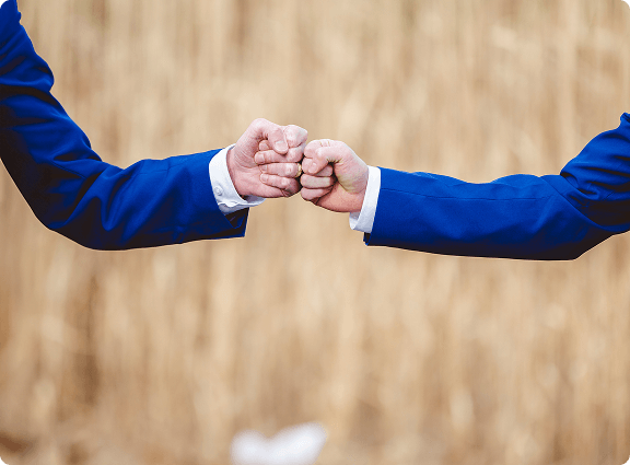 Dwie ręce przybijające sobie żłówika.